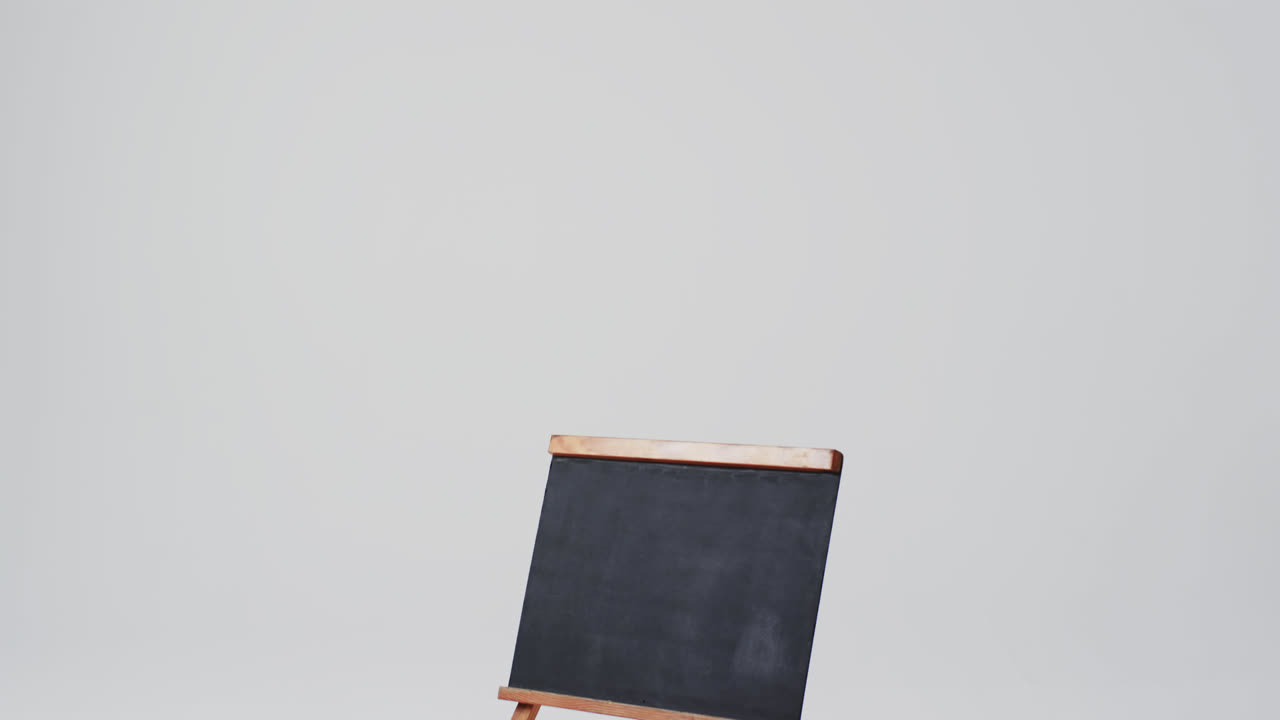 Video of blackboard sign on wooden stand with copy space on white background