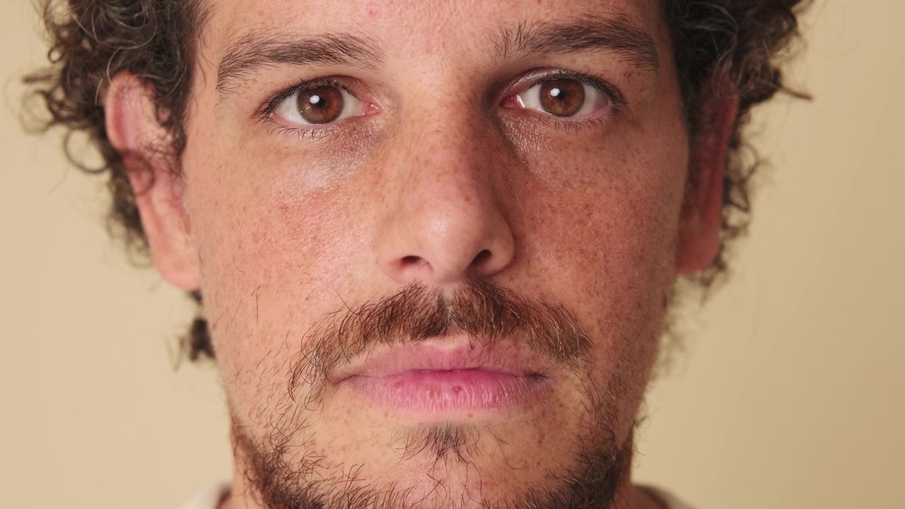 Retrato en primer plano de un joven hombre mirando directamente a la cámara
