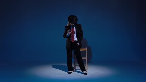 man in suit and fedora posing in a spotlight