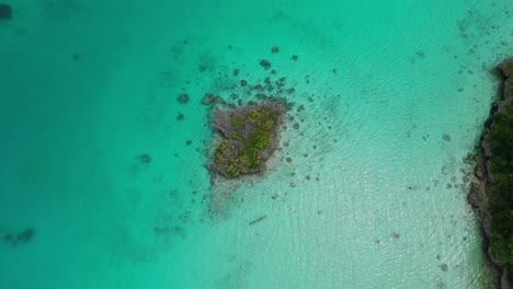 Drone-Flotando-Sobre-Una-Pequeña-Isla-Rocosa-En-La-Laguna-De-Fiji