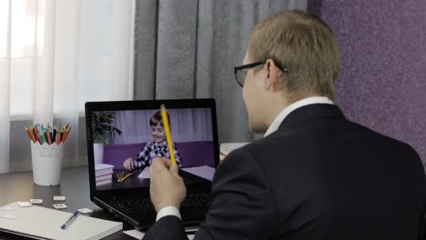 man teacher making video call on laptop with little pupil. distance education