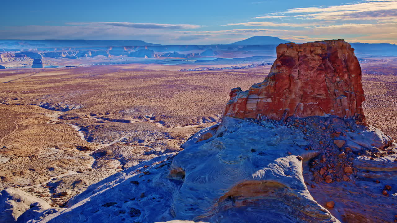 A panoramic drone view encircles Glen Canyon’s weathered rock formations, presenting a surreal desert oasis.