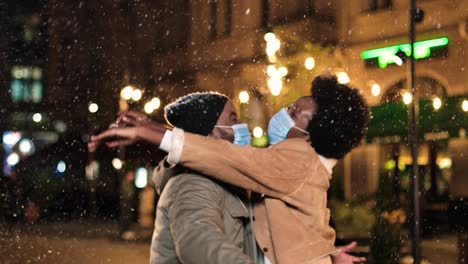 african american man wearing medical mask and giving xmas gift to his wife on new year's eve