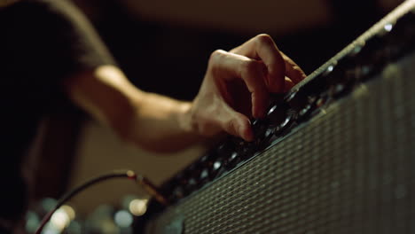 Unrecognizable-person-preparing-equipment-in-studio.-Man-hand-turning-knobs.