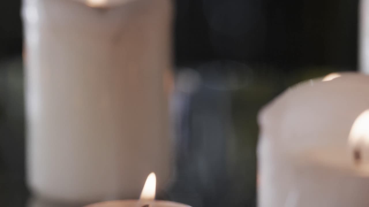 Video di candele bianche con fiamme bianche e spazio per il testo con effetto bokeh su sfondo nero