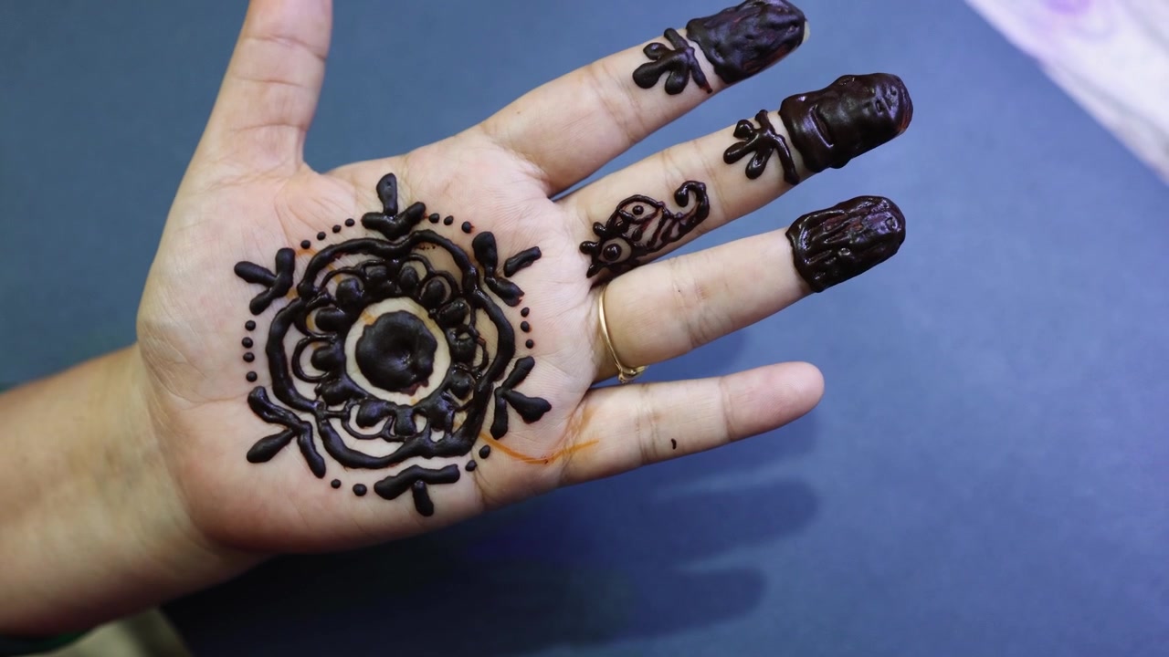 Primo piano della mano con un fresco motivo Mehndi all'henné sulla mano di una donna