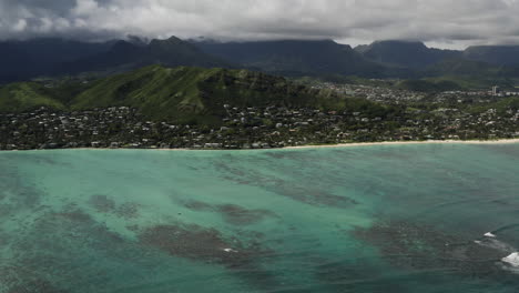beautiful aerial view above clear green oahu ocean water toward lanikai beach, hawaii