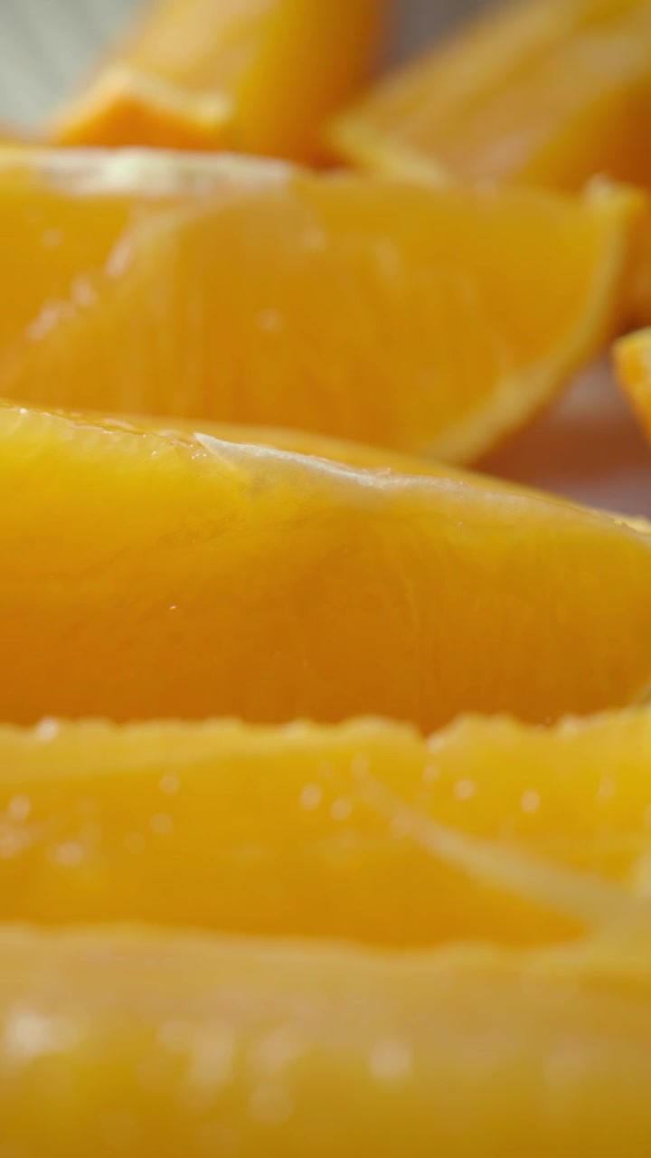Primo piano di spicchi d'arancia succosi appena tagliati.