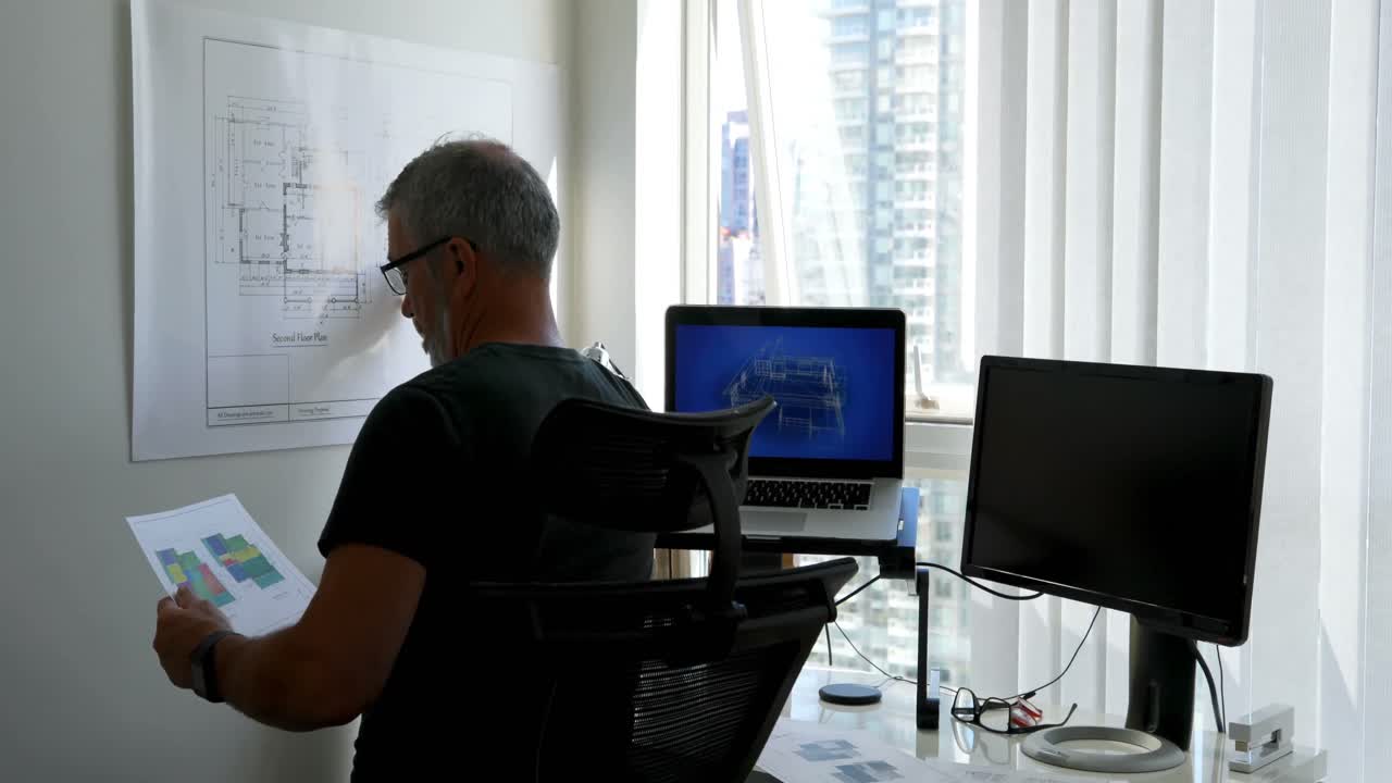 hombre comprobando el plano en el escritorio 4k