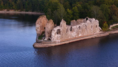 aerial close up of koknese castle ruin complex in koknese, latvia, situated on a high bluff overlooking the daugava river valley drone footage at sunset