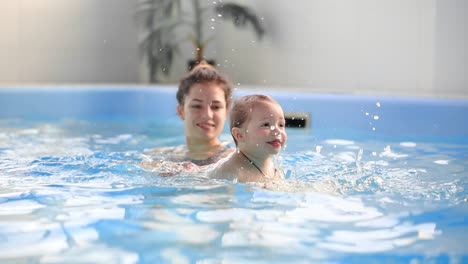 cute baby boy enjoying with his mother in the pool.