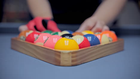 Billiard-player's-hands-with-gloves-moves-and-levels-the-pyramid-of-balls