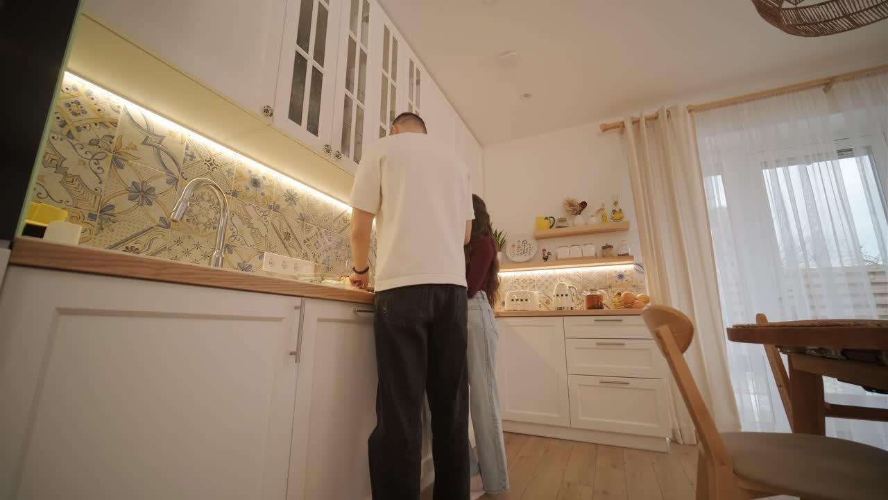 una pareja enamorada haciendo un sándwich en la cocina de la sala de estar