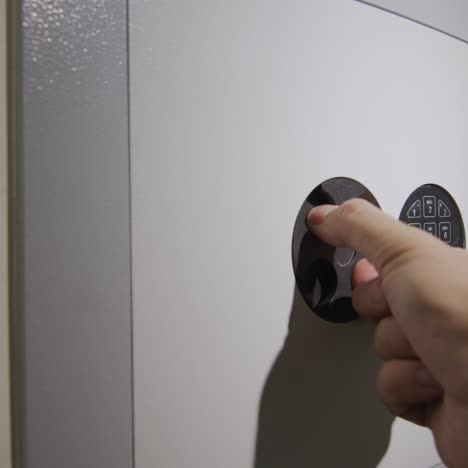 the man enters the password on the door of the safe and takes the gun from there