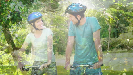 animación de hojas sobre una pareja caucásica sonriente hablando con bicicletas