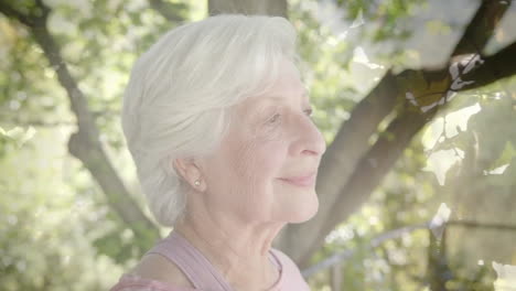 Animación-De-Puntos-De-Luz-Y-árboles-Sobre-Una-Mujer-Caucásica-Mayor-Sonriente-En-El-Jardín