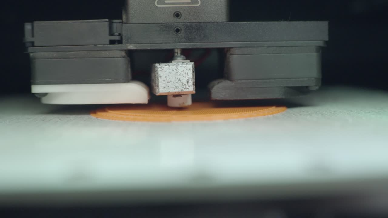 3D Printer Creating Layers on Orange Object
