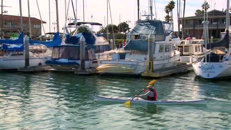 Die-Kamera-Verfolgt-Einen-Kajakfahrer,-Der-Durch-Den-Hafen-Von-Santa-Barbara-Paddelt