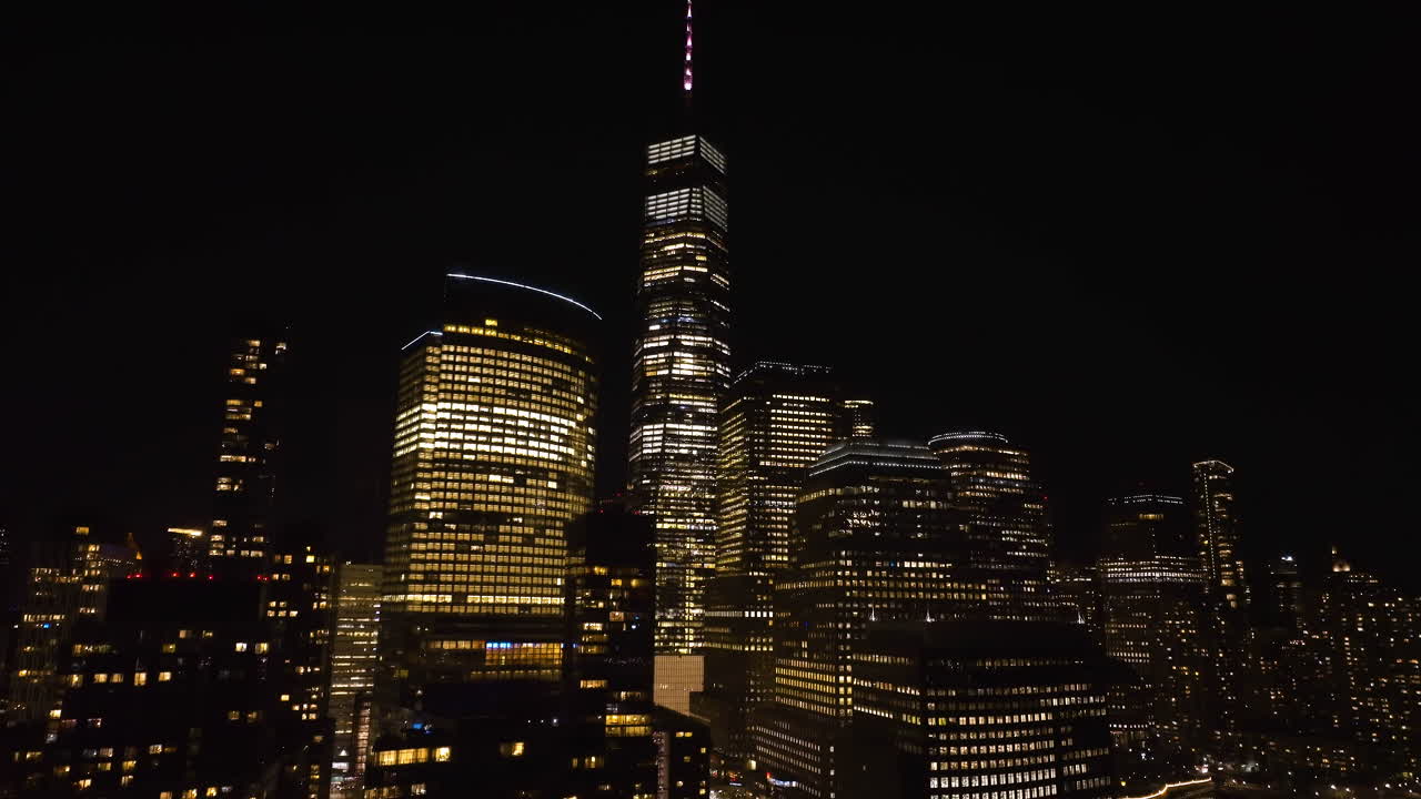 vista aérea ascendente de los rascacielos iluminados en el bajo manhattan, noche en nueva york