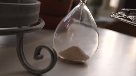 hourglass sand falling in slow motion zoom in