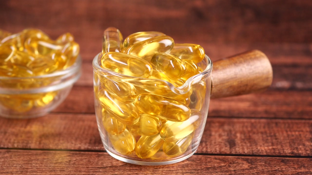 Close-up of Golden Omega 3 Capsules in Glass Bowls