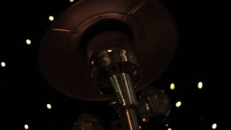 a patio heater in the cold winter with decorative holiday lights in the background