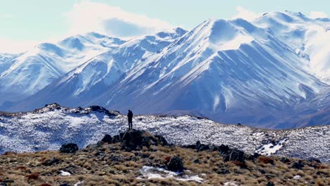 man on mountain peak and panoramic scenic view of new zealand alpine winter snowy landscape