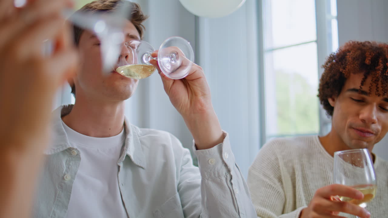 Festive friends toasting champagne celebrating birthday at apartment closeup
