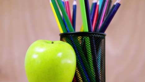 pen holder with color pencil and apple