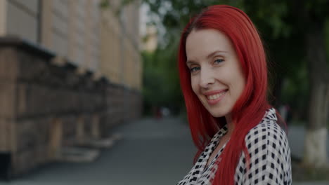 woman with red hair smiling outdoors