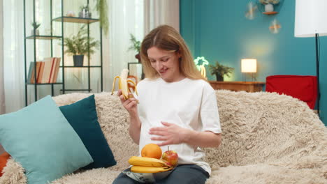 pregnant woman eats apples bananas healthy snack thumbs up cares health indoor break smiling joyful