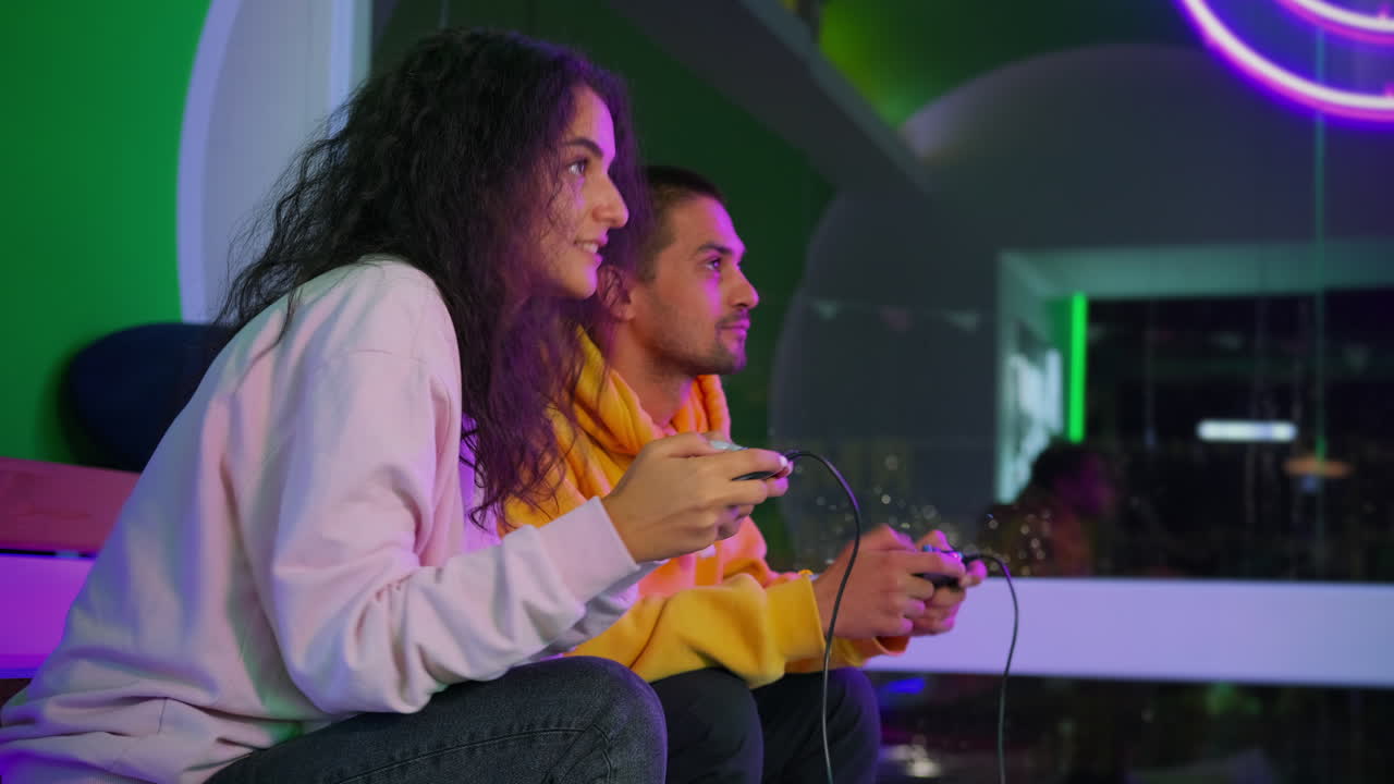 Pareja jugando en un salón recreativo nocturno