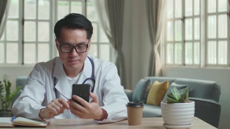 man doctor video call on mobile phone at home office, video in 4k