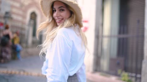 slow motion:attractive young beautiful girl with hat walks and discovers places in narrow street