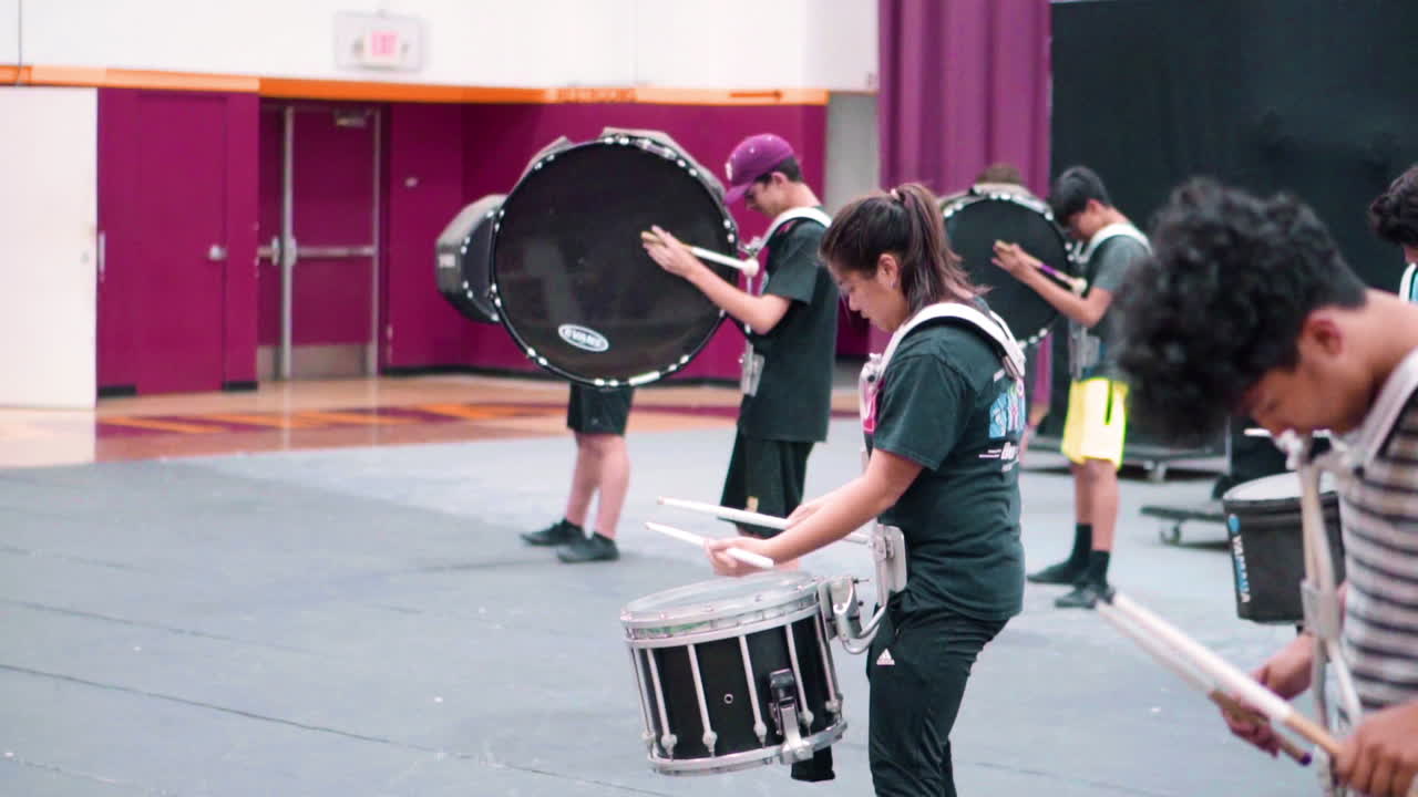 High school students rehearsing music and movement to the show they are to perform.