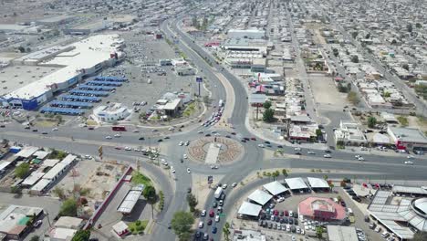 view from a drone flying away from a monument of the mexican ex-president francisco zarco in the middle of a roundabout in the city of mexicali