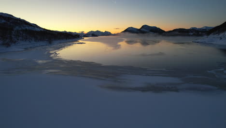 moody sunset low fly over frozen fjord during the polar night season - northern norway - scandinavia - jornfjorden