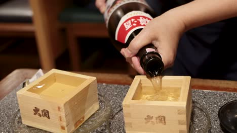 pouring sake into square wooden box