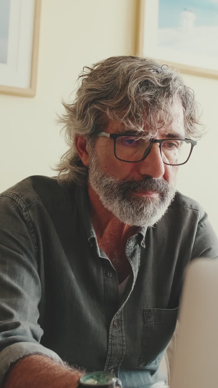 Portrait of a man with gray hair and beard wearing glasses
