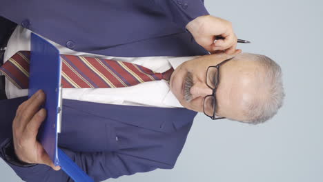 Vertical-video-of-Old-businessman-scratching-his-ear.