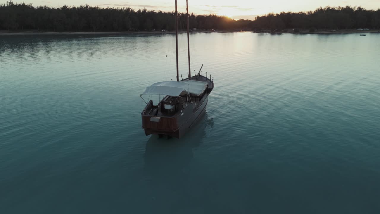 Aesthetic aerial footage of a pirate-style boat on tranquil waters in Mauritius at sunset. Concept of secluded travel, peaceful moments, and tropical moments. Ideal for tourism and relaxation videos