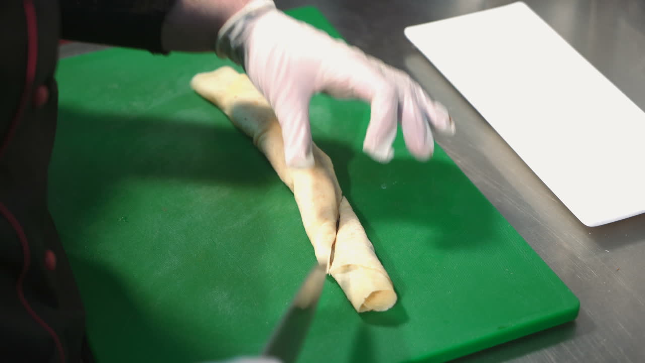 Chef cutting pancakes on a board. Tasty sweet pancake rolls with topping.