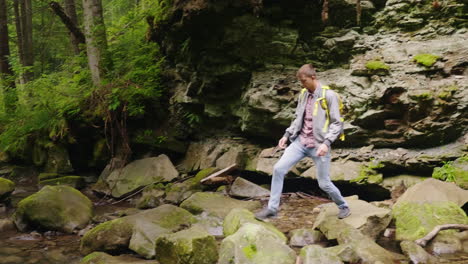 A-Tourist-With-A-Backpack-Crosses-A-Mountain-River-Over-Rocks-The-Dangerous-Moment---Almost-Falls-Sl