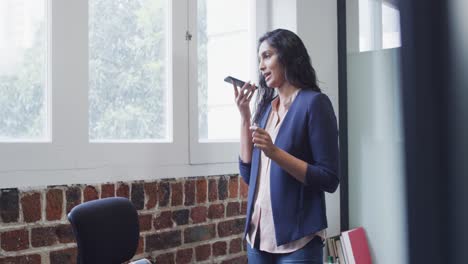 Frau-Spricht-Im-Büro-Auf-Dem-Smartphone