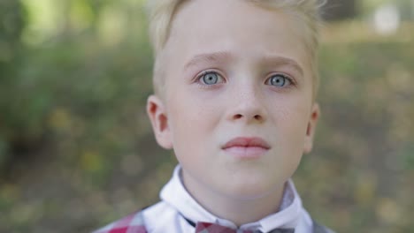 teen boy of european appearance close up a boy with blond hair a little boy with blond hair and gray eyes looks into the camera lens