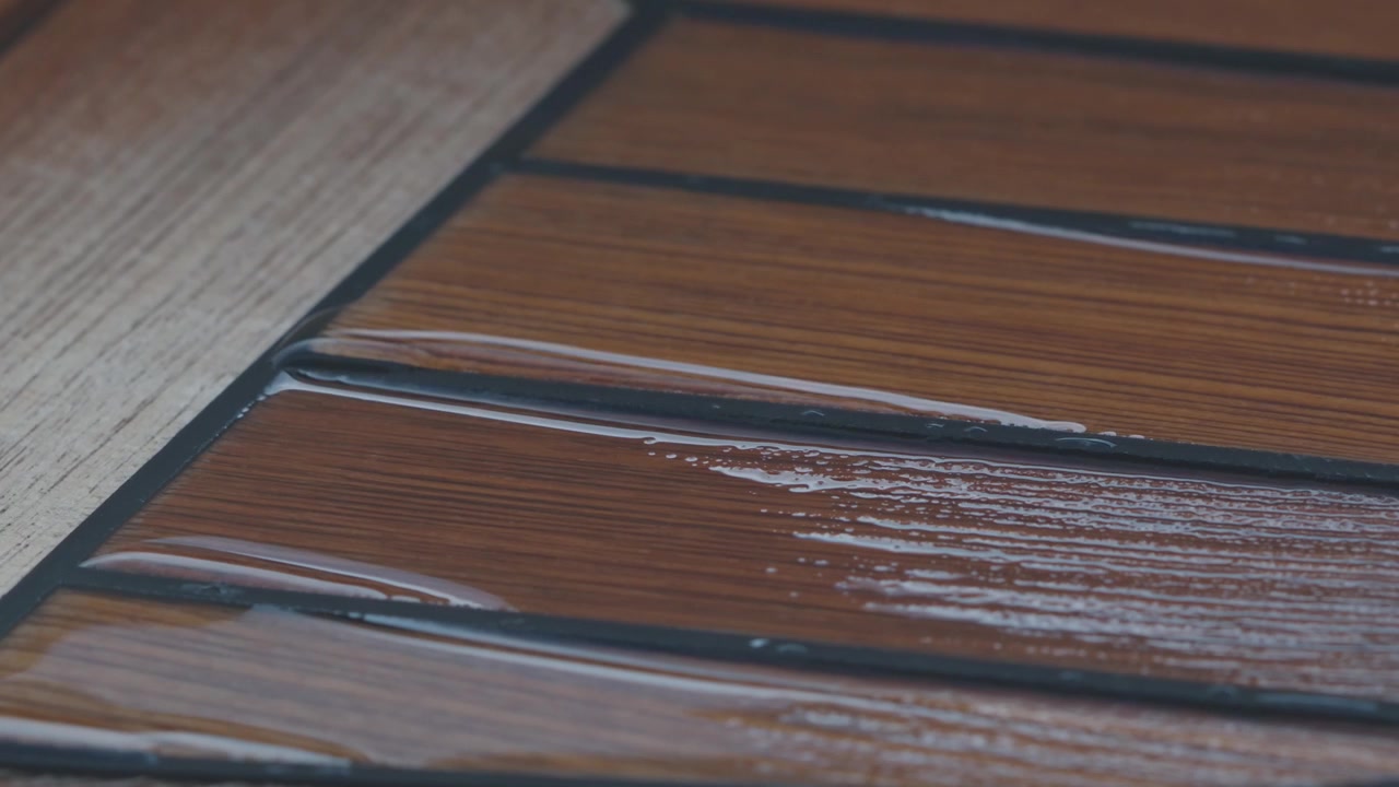 Dell'acqua sul ponte in teak dopo la pioggia