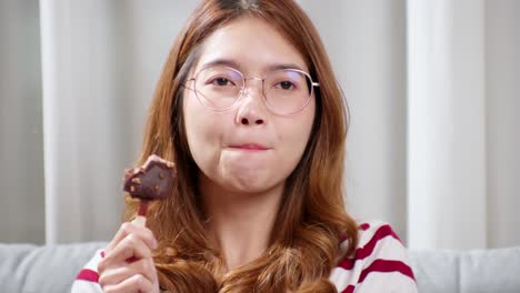 초콜릿 아이스크림을 시음하는 안경에 아시아 젊은 여자