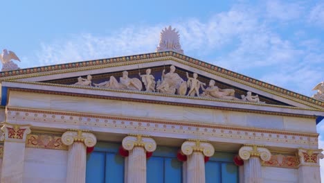 exterior facade including marble statues, ionic columns, and detailed artwork on the academy of athens building, greece