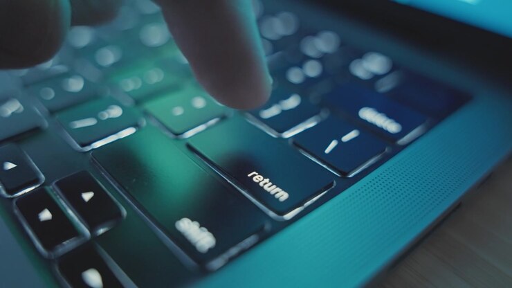 Close up of various clicks on Return or Enter key button on laptop keyboard. Dark office desk or home. Person or hacker presses and pushes to start and initiate task action entering into app software