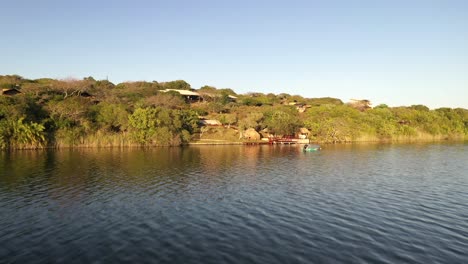 Toma-Aérea-Ascendente-Del-Lago-Inhampavala-En-Chindeguele-Mozambique-Durante-La-Hora-Dorada-Del-Amanecer